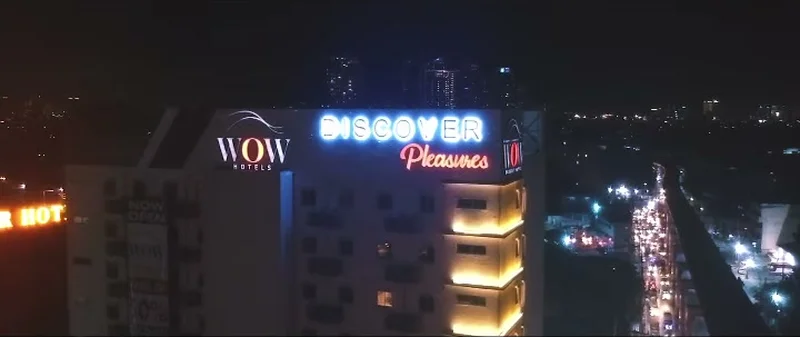 Illuminated rooftop building signage viewed from above at night